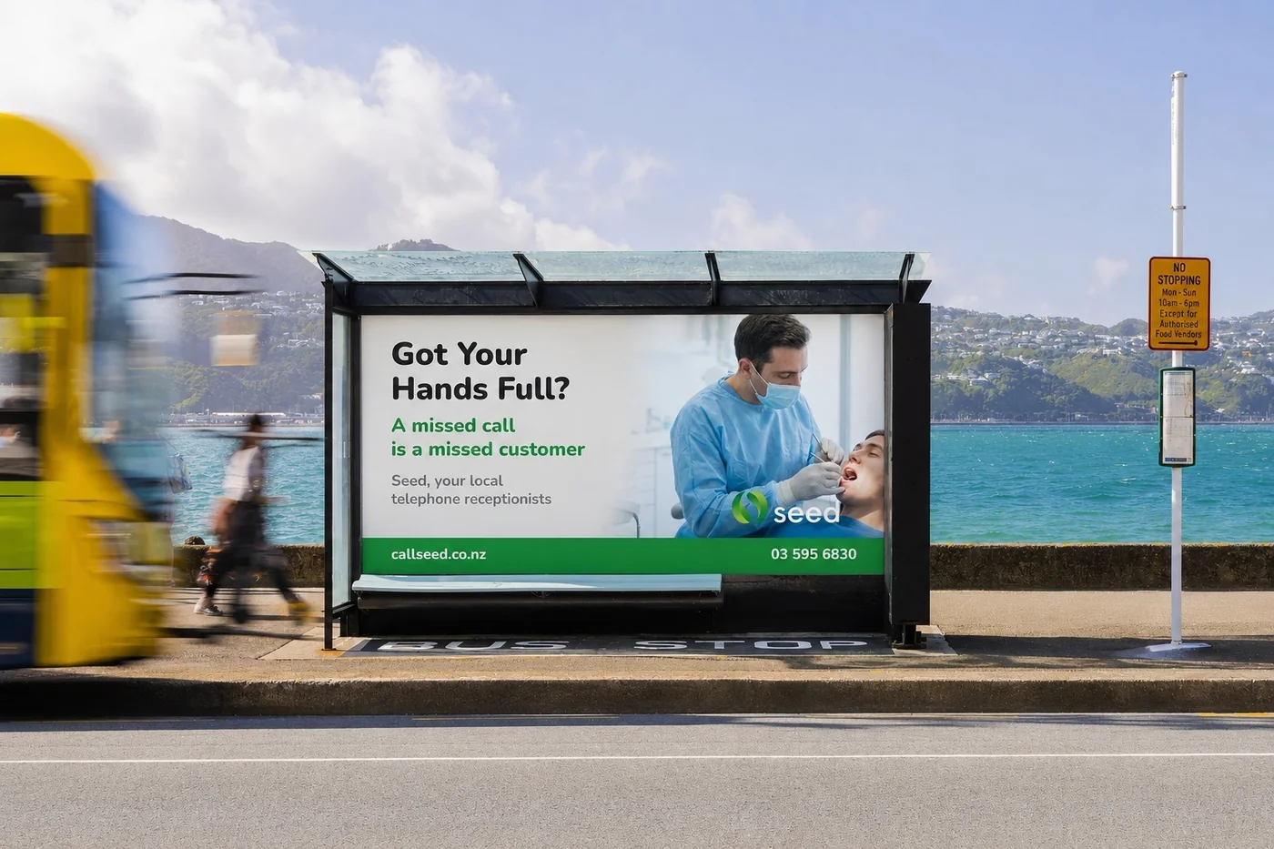 Seed bus-shelter billboard by the water reading Got Your Hands Full? A missed call is a missed customer. Seed, your local telephone receptionists